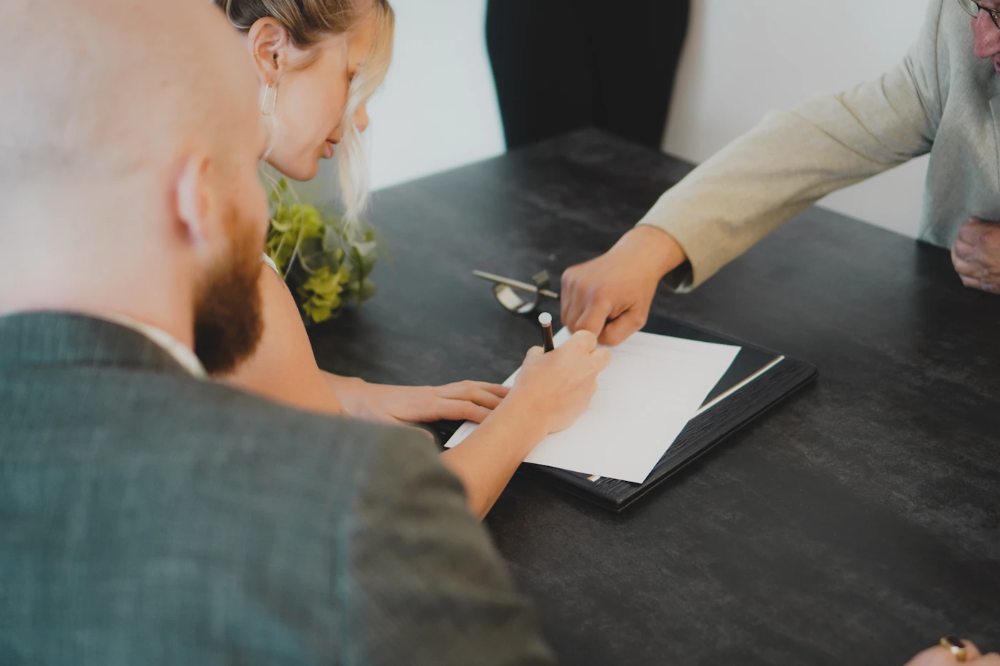 A couple signing duplicate originals at a desk